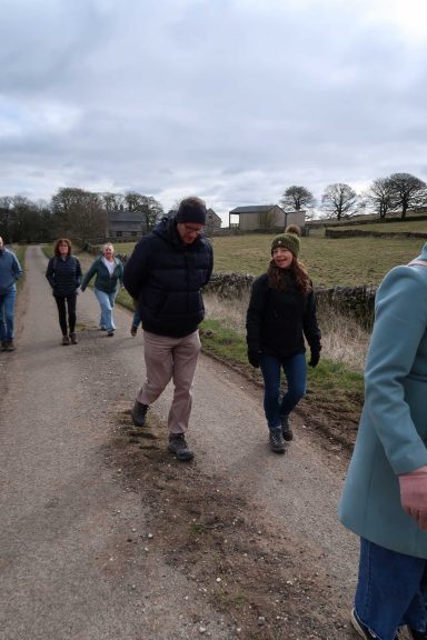 Group of people walking along a country path on a cloudy day during an Immersive Spanish retreat in the Peak District
